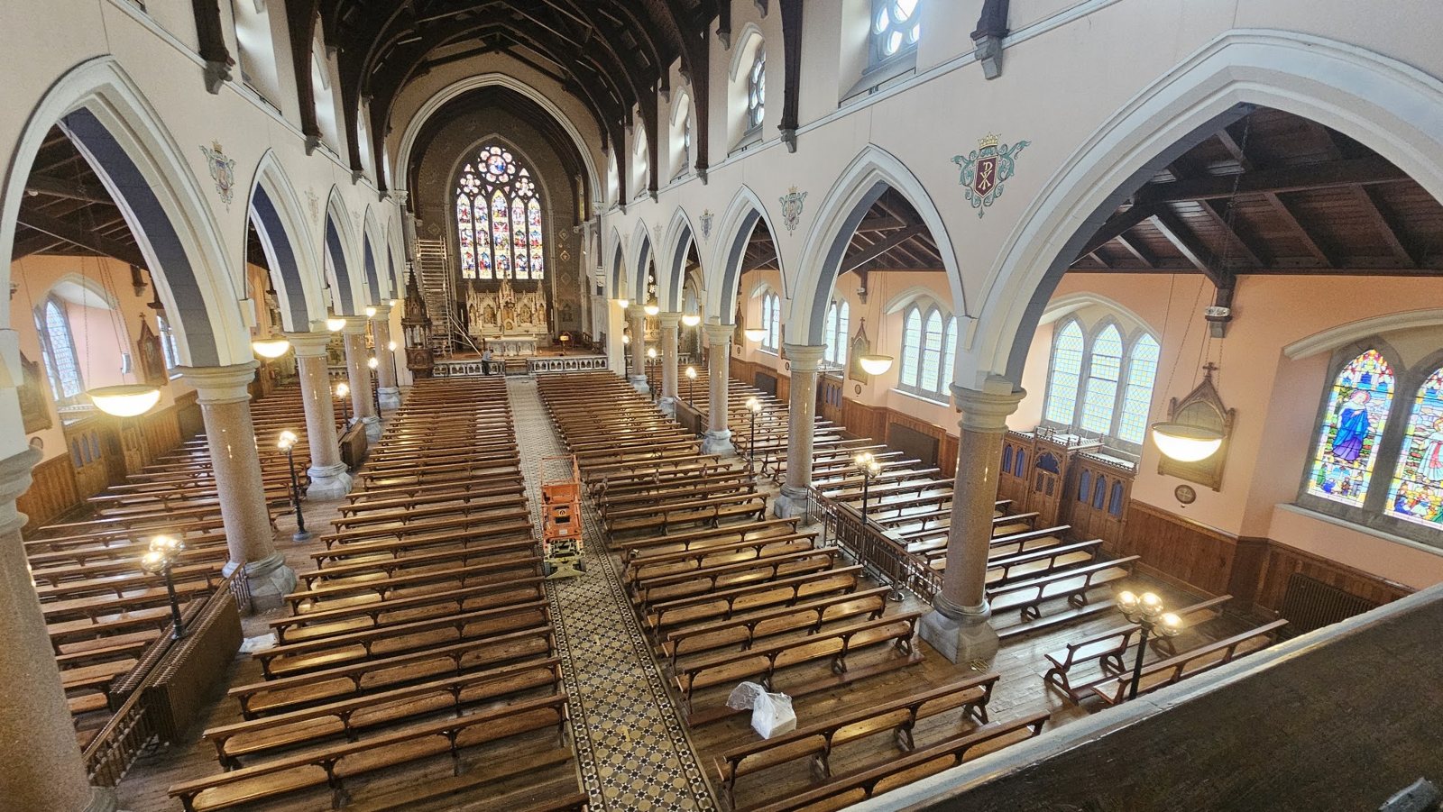 Inside a church: the nave, pews and a row of pendant lights