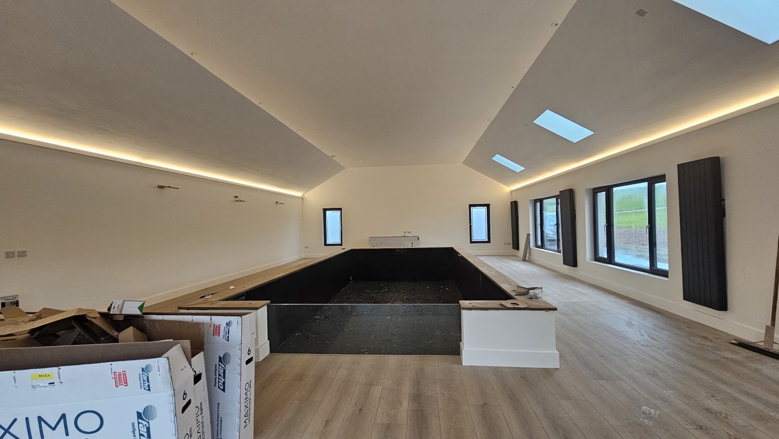 A long room with recessed lighting under a vaulted ceiling