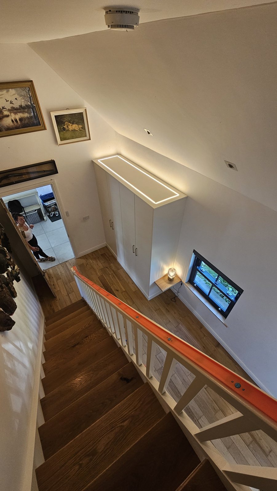 A stairwell with wall lights and a ceiling smoke alarm