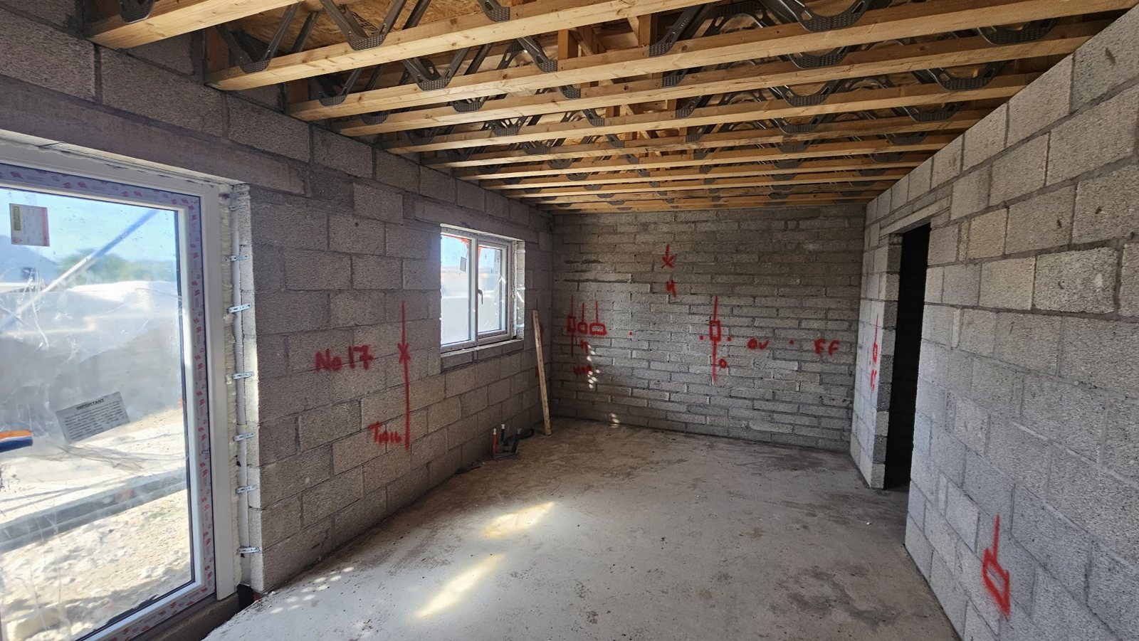 A blockwork room at first fix, marked out in red